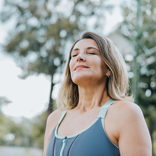 Women in sports outfit taking a deep breath and feeling relief from her symptoms and side-effects after doing a PGx test